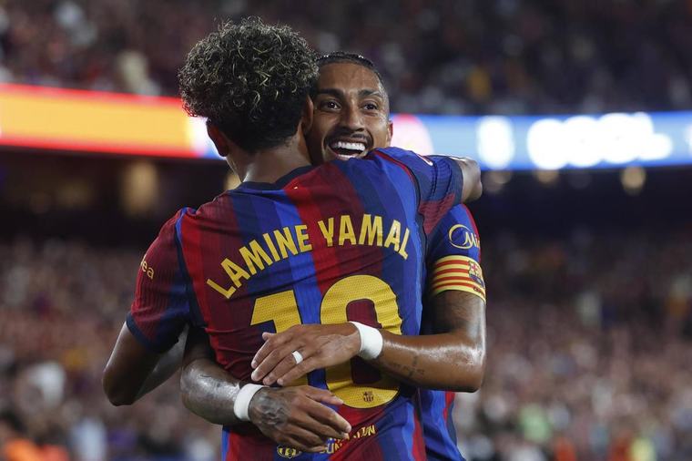 El delantero del FC Barcelona Lamine Yamal celebra con Raphinha su gol, segundo gol del equipo blaugrana, en el partido de la tercera jornada de LaLiga. ( Quique García / EFE )